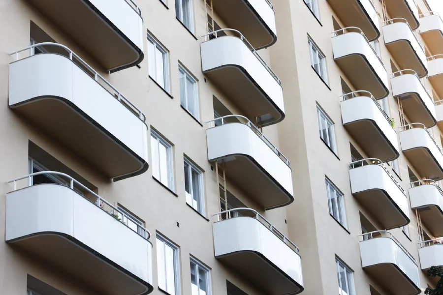Fasad på flerbostadshus med vita balkonger.